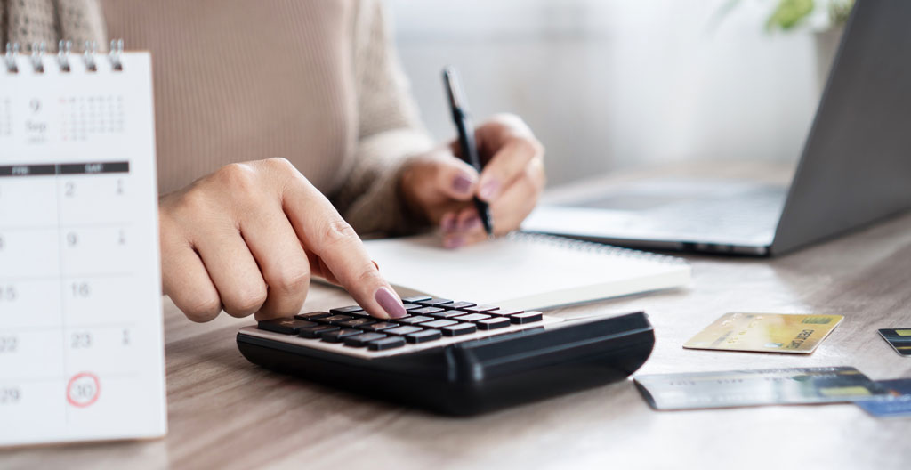 Agenda papier ouvert sur un bureau avec dates clés d'un projet de crédit immobilier annotées en français (compromis, clause suspensive, rendez-vous banque)